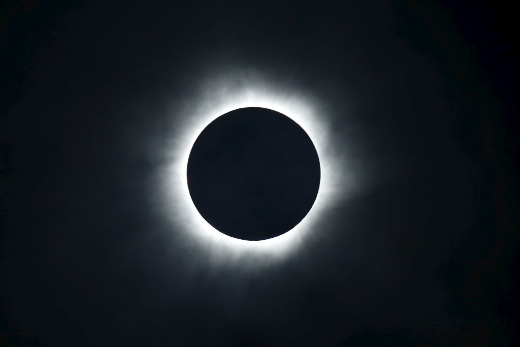 A total solar eclipse is seen from the beach of Ternate island